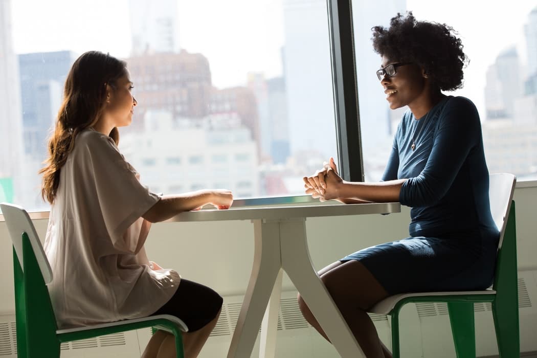 Two women having a conversation at work.