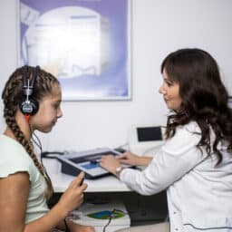 Audiologist conducting a hearing test with a young girl
