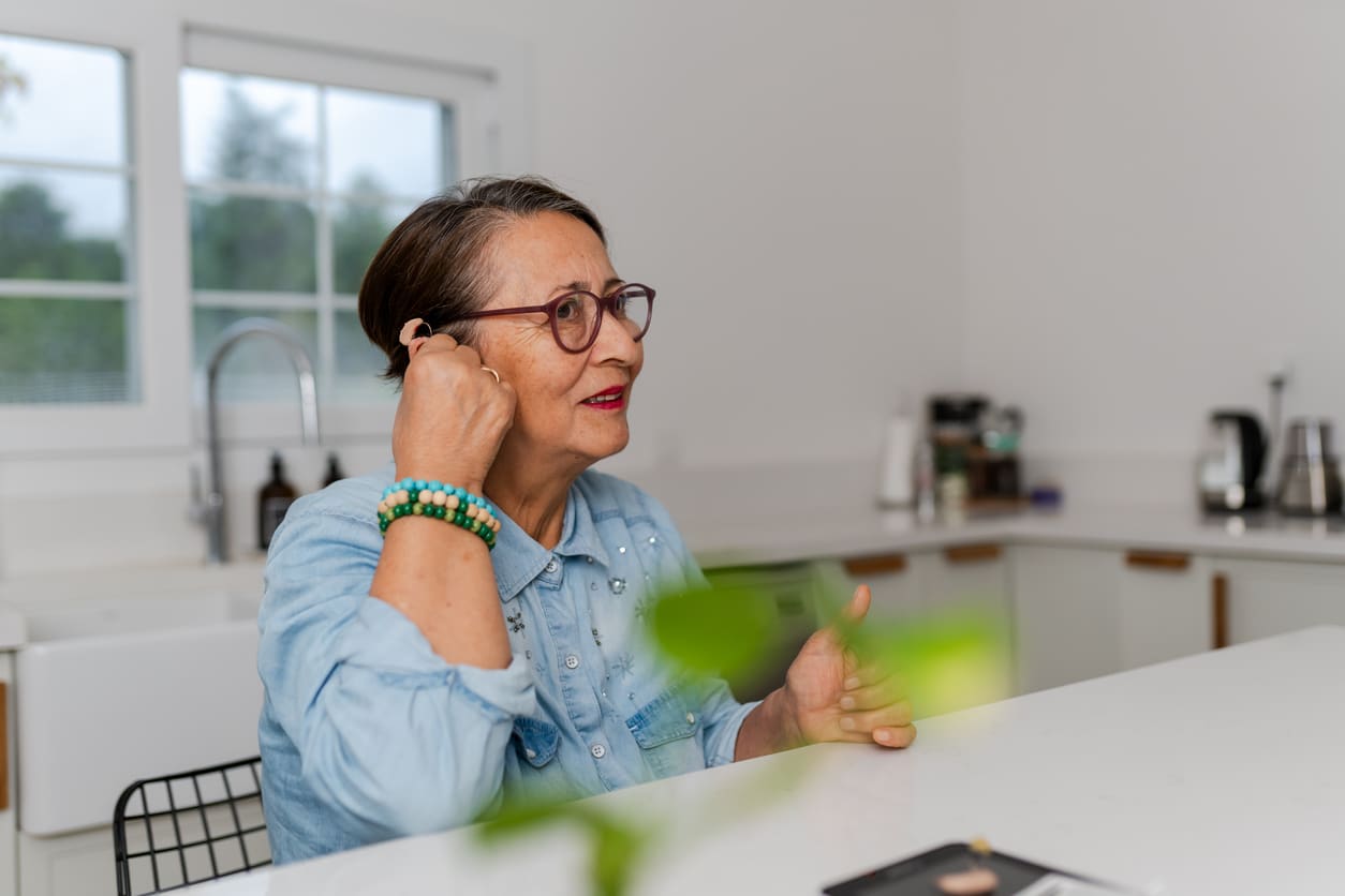 Woman adjusting her new hearing aid.